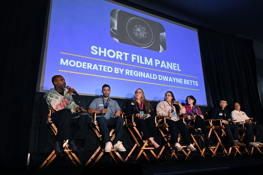 El poeta estadounidense y defensor de la reforma penitenciaria Reginald Dwayne Betts (izq.) dirige un panel con cineastas durante el Festival de Cine de San Quentin en el Centro de Rehabilitación de San Quentin en San Quentin, California, el 24 de octubre de 2025.