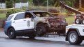 Un vehículo policial quemado siendo remolcado fuera de una estación de policía en el sureste de Raleigh, Carolina del Norte, el sábado 7 de mayo de 2022. 