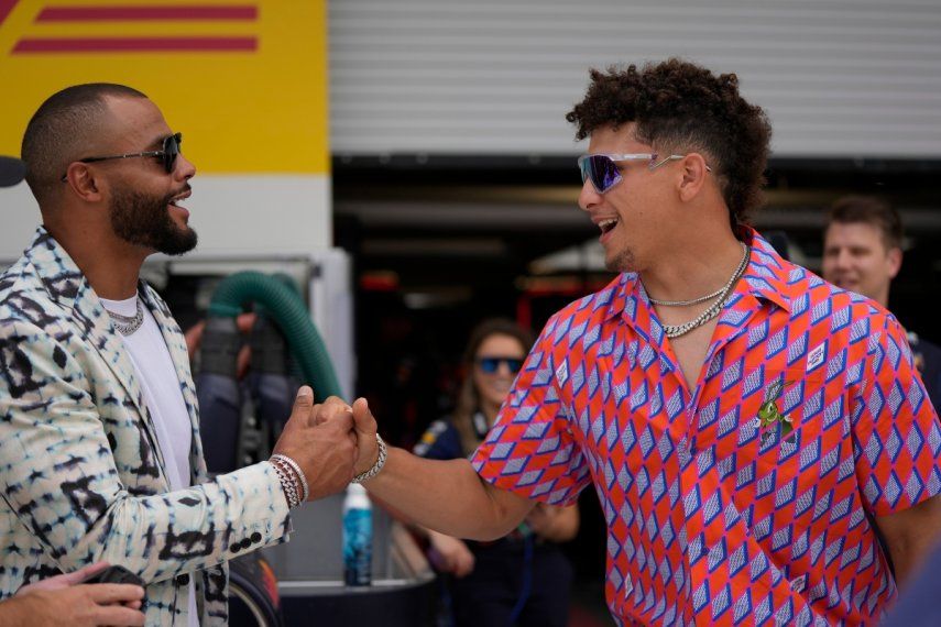 El mariscal de campo de los Dallas Cowboys, Dak Prescott, a la izquierda, y el mariscal de campo de los Kansas City Chiefs, Patrick Mahomes, se saludan en el garaje de Red Bull antes de la carrera de autos del Gran Premio de Fórmula Uno de Miami en el Autódromo Internacional de Miami, el domingo 7 de mayo de 2023, en Miami Gardens, Florida. Mahomes irá con su equipo campeón a un duelo en Alemania para la gira de NFL en el que enfrentarán a los Dolphins de Miami.