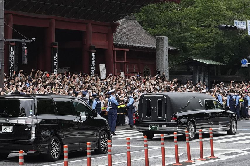 Un auto fúnebre (derecha) con el cuerpo del exprimer ministro de Japón Shinzo Abe parte del templo de Zojoji tras su funeral, en Tokio, el 12 de julio de 2022. (AP Foto/Hiro Komae