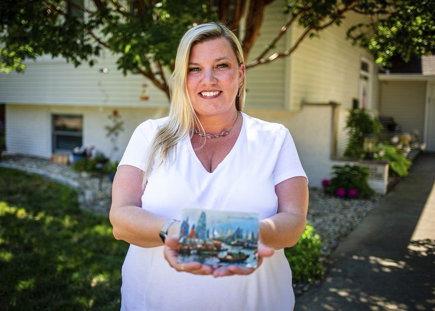 Kim Draper muestra la postal que recibió en su casa en Springfield el 8 de julio de 2019, exactamente 26 años después de que fuera enviada a la familia que antes vivía en su domicilio.
