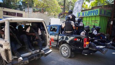 Unos policías vigilan tras recuperar los cuerpos de dos periodistas que fueron asesinados por pandillas en Puerto Príncipe, Haití, el 7 de enero de 2022.