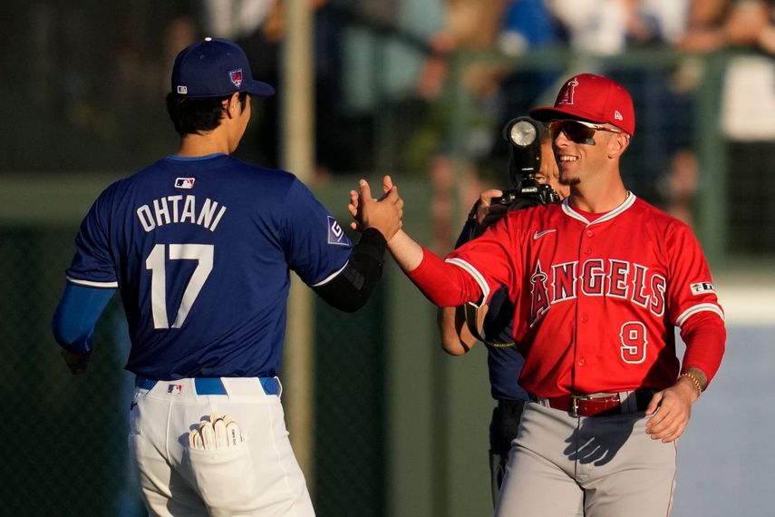 El bateador designado de los Dodgers de Los Ángeles, Shohei Ohtani (17), saluda al campocorto de los Angelinos de Los Ángeles, Zach Neto (9), antes de un partido de béisbol de entrenamiento de primavera en Phoenix, el martes 5 de marzo de 2024. 