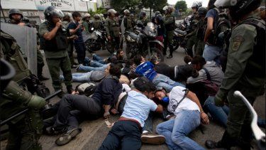 Policía Bolivariana mantiene reducidos en el suelo a manifestantes que protestan contra el régimen, el 14 de mayo de 2014.
