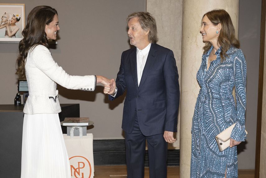 Kate, princesa de Gales, estrecha la mano de Sir Paul McCartney, mientras los observa su esposa Nancy Shevell, durante una visita para reinaugurar la Galería Nacional de Retratos luego de una renovación de tres años, el martes 20 de junio de 2023, en Londres.