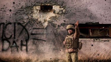 Un militar ucraniano señala en dirección de la que procedió un proyectil, junto a un edificio alcanzado por fuego de morteros de gran calibre en la localidad de Krymske, en Luhansk, en el frente de combates en el este de Ucrania, el sábado 19 de febrero de 2022.&nbsp;