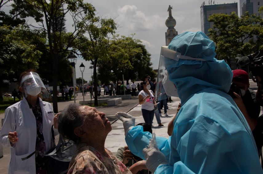 Un trabajador de salud realiza pruebas gratuitas de COVID-19 en una cabina m&oacute;vil, en la plaza El Salvador del Mundo, en San Salvador, el 27 de julio de 2020.&nbsp;