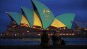 Una pareja observa la Ópera de Sídney iluminada con los colores del equipo australiano durante la campaña de Brisbane para ser sede de los Juegos Olímpicos del 2032 Una pareja observa la Ópera de Sídney iluminada con los colores del equipo australiano durante la campaña de Brisbane para ser sede de los Juegos Olímpicos del 2032