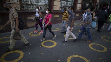 C&iacute;rculos amarillos en el pavimento sirven de gu&iacute;a para que los compradores mantengan la distancia social mientras esperan en fila, para evitar la propagaci&oacute;n del coronavirus, cerca de un popular mercado de Caracas, Venezuela, el 23 de mayo de 2020.&nbsp;