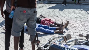 Los cuerpos de dos internos muertos yacen en la acera de la prisión de Croix-des-Bouquets de donde escaparon muchos presos y donde murieron varias personas, en Croix-des-Bouquets, suburbio de la capital haitiana, el 25 de febrero de 2021. Múltiples personas murieron el 25 de febrero en Haití, incluido el director de una prisión en los suburbios de la capital, Puerto Príncipe, luego de que varios presos escaparan, dijo la policía. El inspector de división Paul Hector Joseph, que está a cargo de la prisión civil de Croix des Bouquets, fue asesinado en la prisión, Gary Desrosiers, portavoz de la policía nacional de Haití