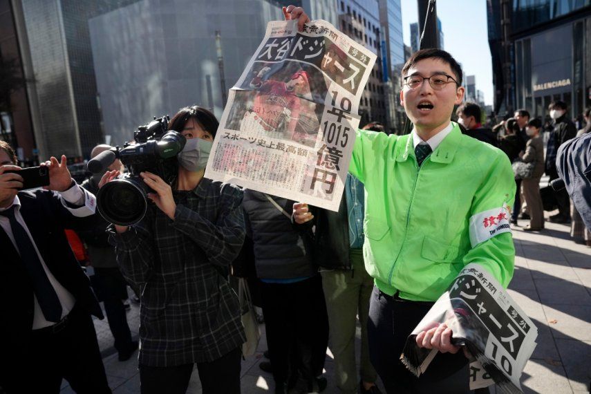 Un empleado distribuye una edición extra del diario Yomiuri Shimbun para informar sobre el pase de Shohei Ohtani a los Dodgers de Los Ángeles, el domingo 10 de diciembre de 2023, en Tokio.