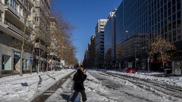 Una mujer cruza una calle nevada en Madrid, España, 11 de junio de 2020. La capital española trata de volver a ponerse en marcha tras una nevada récord que paralizó una gran parte del centro del país.&nbsp;