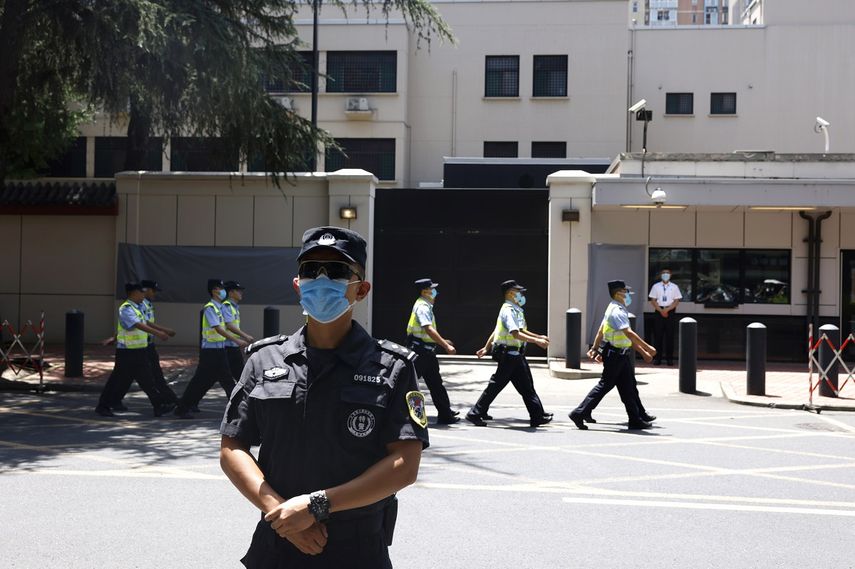 Polic&iacute;as chinos marchan ante el antiguo consulado estadounidense en Chengdu, en la provincia suroccidental china de Sichuan, el lunes 27 de julio de 2020.&nbsp;