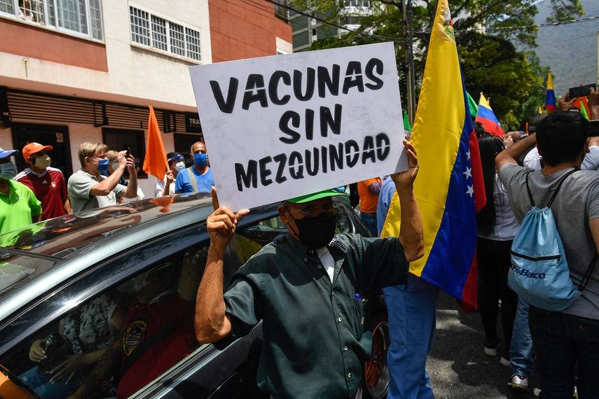 Un activista sostiene un cartel que dice “Vacunas sin mezquindad” durante una protesta de venezolanos para exigir que todos los trabajadores de la salud sean vacunados contra el COVID-19, en la plaza Los Palos Grandes, en Caracas el 17 de abril de 2021. &nbsp;