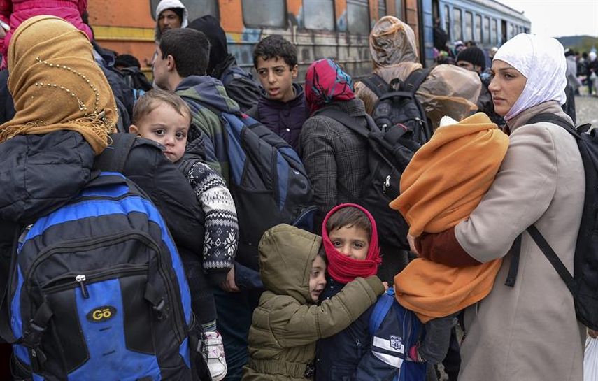 Varios refugiados se agolpan para subir a un tren antes de partir hacia a la frontera serbia, cerca de la ciudad de Gevgelija, Macedonia, este, 23 de octubre de 2015 (EFE)