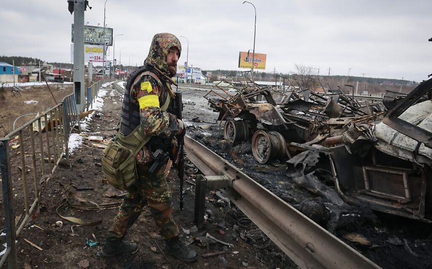 Soldados ucranianos vigilan una entrada a Kiev, tras destruir incursión militar rusa.