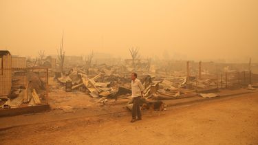 Un hombre camina junto a los escombros después que un incendio forestal arrasara con la localidad de Santa Olga región del Maule, a unos 260 km al sur de Santiago de Chile (Chile).