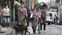 Los miembros del grupo Circo Encuentro caminan por una calle con alimentos donados que recibieron a cambio de sus presentaciones en Bogot&aacute;, Colombia, el s&aacute;bado 4 de julio de 2020.&nbsp;