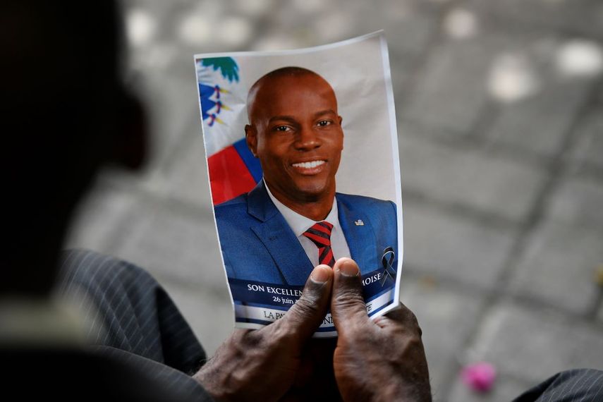 Una persona sostiene una fotografía de difunto presidente Jovenel Moïse durante una ceremonia fúnebre en el Museo y Cementerio Nacional, el martes 20 de julio de 2021, en Puerto Príncipe, Haití. 