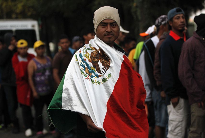 Un migrante hondureño, que integra la caravana que pretende llegar a Estados Unidos, se arropa con una bandera mexicana.