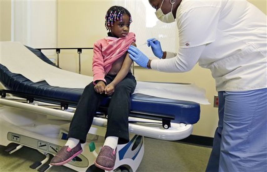 Niña es vacunada contra la gripe.