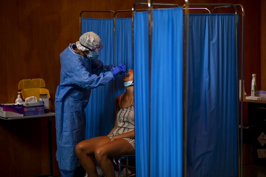 Un voluntario español con una torunda realiza una prueba de COVID-19 a una mujer en Vilafranca del Penedes, Barcelona, España, 13 de agosto de 2020. 