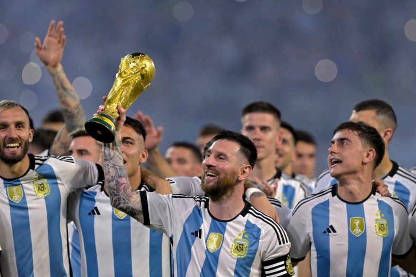 Lionel Messi (centro) levanta una réplica del trofeo de la Copa del Mundo frente a sus compañeros en una ceremonia.
