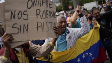 Los trabajadores públicos jubilados gritan la consigna española ¡El pueblo unido jamás será vencido! durante una protesta de trabajadores públicos exigiendo que el gobierno pague todos sus beneficios y respete los convenios colectivos en Caracas, Venezuela, el jueves 11 de agosto de 2022. El letrero dice en español ONAPRE, nos robaste sin un arma, refiriéndose a la oficina nacional de presupuesto.&nbsp;