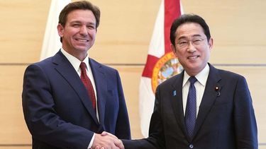 El gobernador de Florida, Ron DeSantis, estrecha la mano del primer ministro japonés, Fumio Kishida.