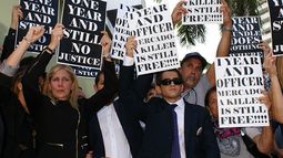 La madre de Israel Hernández sostiene un cartel pidiendo justicia el miércoles durante la vigilia en Miami Beach. (Frank Díaz Donikián)