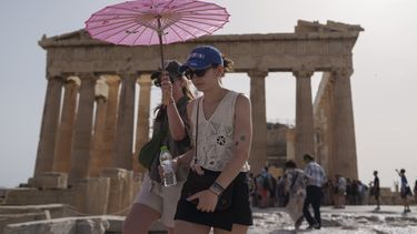 Turistas caminan por la Acrópolis, en Atenas, Grecia, bajo el fuerte calor, el 12 de junio de 2024. 