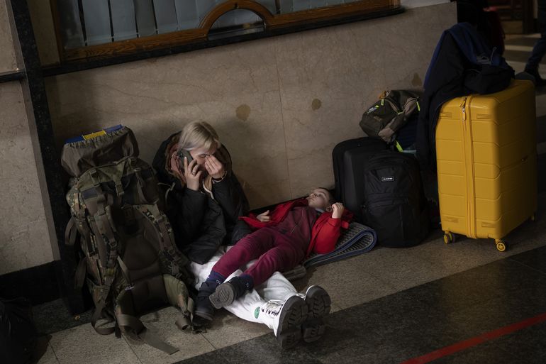 Una mujer con su hija espera a un tren mientras tratan de abandonar Kiev, en Ucrania, el jueves 24 de febrero de 2022. 
