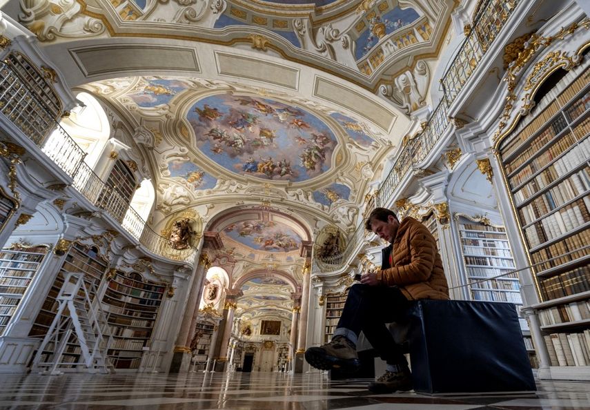 Se ve a un visitante en la biblioteca de la abadía benedictina en Admont, Austria, el 6 de diciembre de 2022. La biblioteca de la abadía de Admont ha construido una fuerte presencia en las redes sociales, con interiores barrocos que atraen a multitudes. &nbsp;