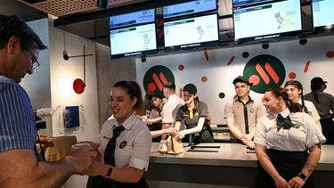 Un empleado le da a un cliente su pedido de comida en la versión rusa de un antiguo restaurante McDonalds después de la ceremonia de apertura en Moscú el 12 de junio de 2022.&nbsp; 