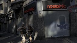 Soldados patrullan una calle para asegurar el cumplimiento de la poblaci&oacute;n de una cuarentena en medio de la pandemia del nuevo coronavirus, en Santiago de Chile, el s&aacute;bado 18 de abril de 2020.&nbsp;