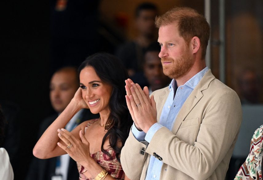 El príncipe Harry, duque de Sussex, y su esposa Meghan Markle reaccionan mientras asisten a un espectáculo durante una visita al Centro Nacional de las Artes en Bogotá el 15 de agosto de 2024.