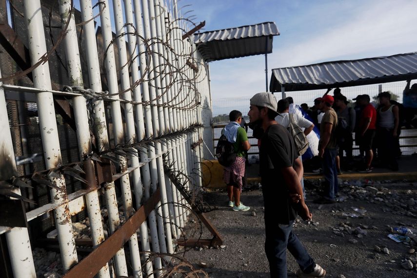 Un grupo de migrantes espera para ingresar a territorio mexicano en el límite fronterizo con Guatemala.