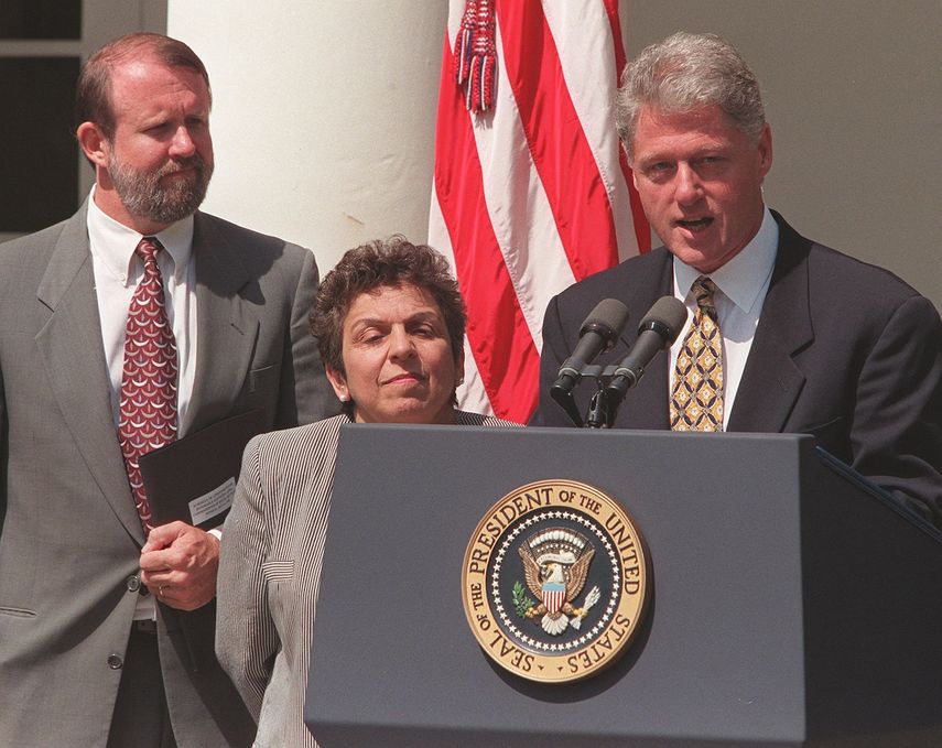 El presidente estadounidense Bill Clinton (derecha) hace una declaración sobre la atención médica mientras la Secretaria de Salud y Servicios Humanos, Donna Shalala (centro), y el Administrador de Seguridad Social, Kenneth Apfel (izq.), escuchan, el 6 de julio de 1998 en la Casa Blanca en Washington.&nbsp;
