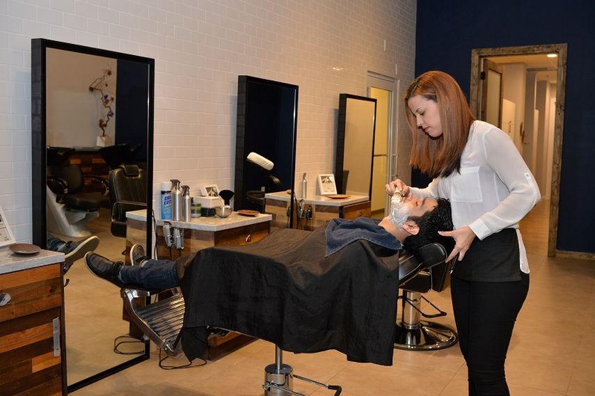 La barbera Jessica Pérez afeita a un cliente. (ÁLVARO MATA). 