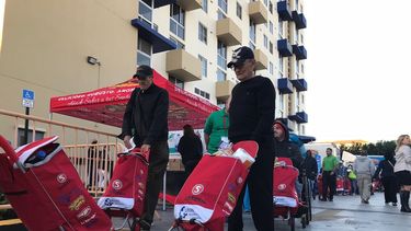 Algunos residentes de Miami en el momento de recoger sus jabas navideñas.