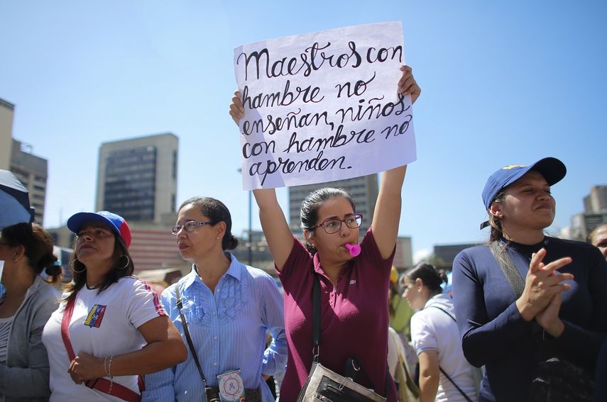 Una maestra sostiene un cartel durante una protesta frente al Ministerio de Educación en Caracas, Venezuela, el martes 22 de octubre de 2019.