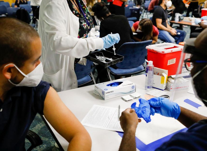 Una trabajadora de la salud entrega dosis de la vacuna Johnson & Johnson contra COVID-19 en el Aeropuerto Internacional de Miami, en Miami, Florida.