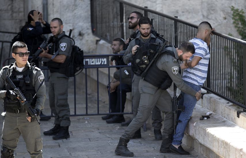 Un policía israelí registra a un joven palestino en la puerta de Damasco en el centro de Jerusalén.&nbsp;