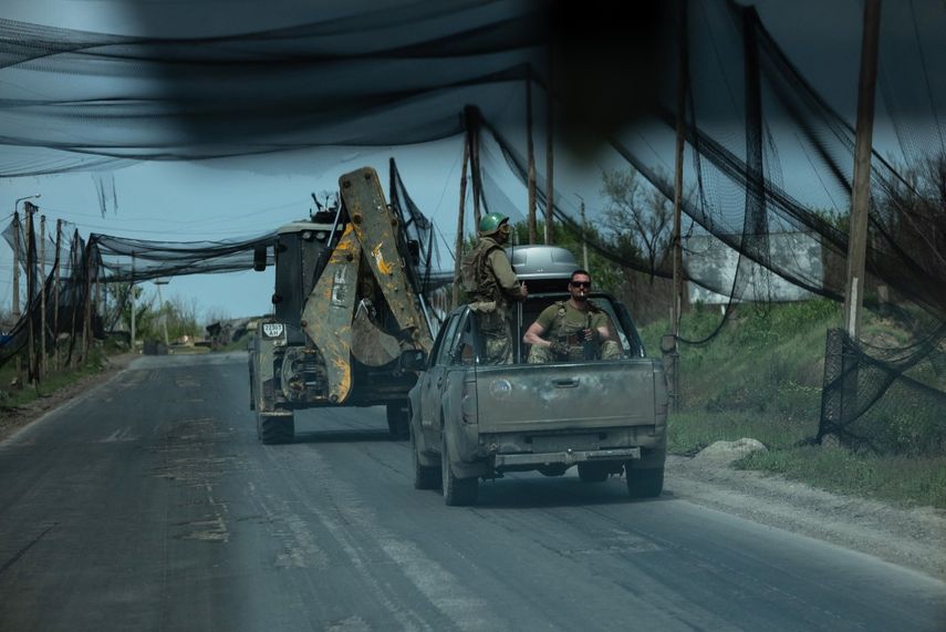 En esta fotografía distribuida el 7 de mayo de 2026 y publicada el 8 de mayo de 2026 por el servicio de prensa de la 93.ª Brigada Mecanizada Separada de Kholodnyi Yar de las Fuerzas Terrestres de Ucrania, militares ucranianos del batallón Cuervo Negro viajan en vehículos por una carretera cubierta con una red para proteger los vehículos de los ataques de drones en un lugar no revelado, en medio de la invasión rusa de Ucrania.&nbsp;&nbsp;