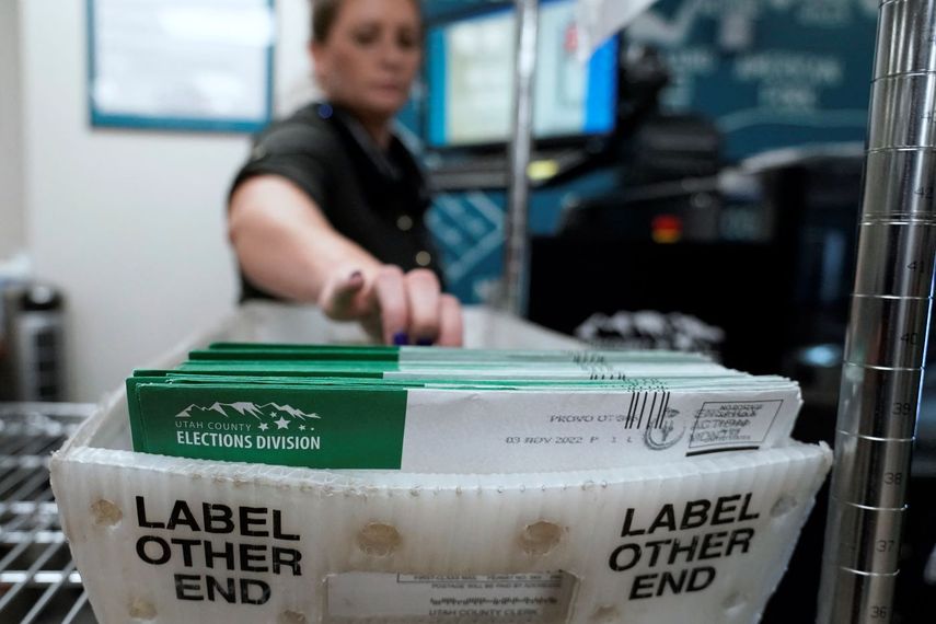 Una empleada del correo colecta boletas de votación.