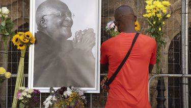 Un doliente lleva flores a la catedral de St. Georges, donde se instaló un Muro en memoria del ícono sudafricano anti-apartheid, el arzobispo Desmond Tutu, después de la noticia de su muerte, en Ciudad del Cabo el 26 de diciembre de 2021.&nbsp; 