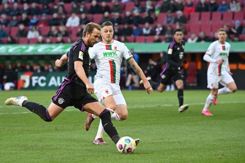 Harry Kane del Bayern Múnich dispara el balón superando a Jeffrey Gouweleeuw del Augsburg en el encuentro de la Bundesliga, el sábado 27 de enero del 2024.