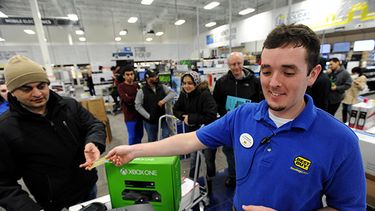 Un empleado de Best Buy, devuelve una tarjeta de crédito a un cliente que compró un juego de video de casi 500 dólares en Dunwoody, Georgia, a los pocos minutos del inicio del Viernes Negro, el día de mayores ventas en Estados Unidos. (AP Foto/David Tu