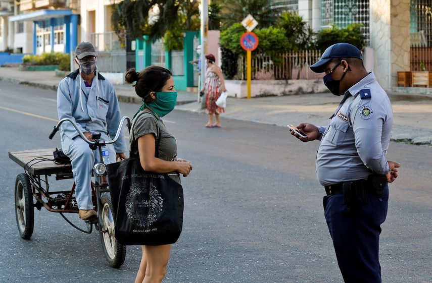 Un agente de la polic&iacute;a del r&eacute;gimen verfica a ciudadanos cubanos en las calles de La Habana, el 4 de abril de 2020.