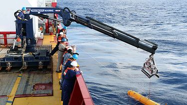 El barco australiano Ocean Shield deposita en el agua un sumergible teledirigido para participar en la búsqueda del avión malasio perdido. (Foto AP/Fuerzas de Defensa de Australia, teniente Kelli Lunt)